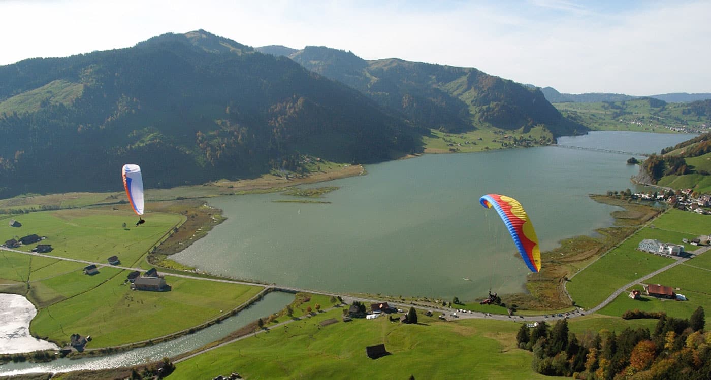 Zwei Hochleister-Gleitschirme soaren im kleinen und feinen Fluggebiet Euthal am Sihlsee.